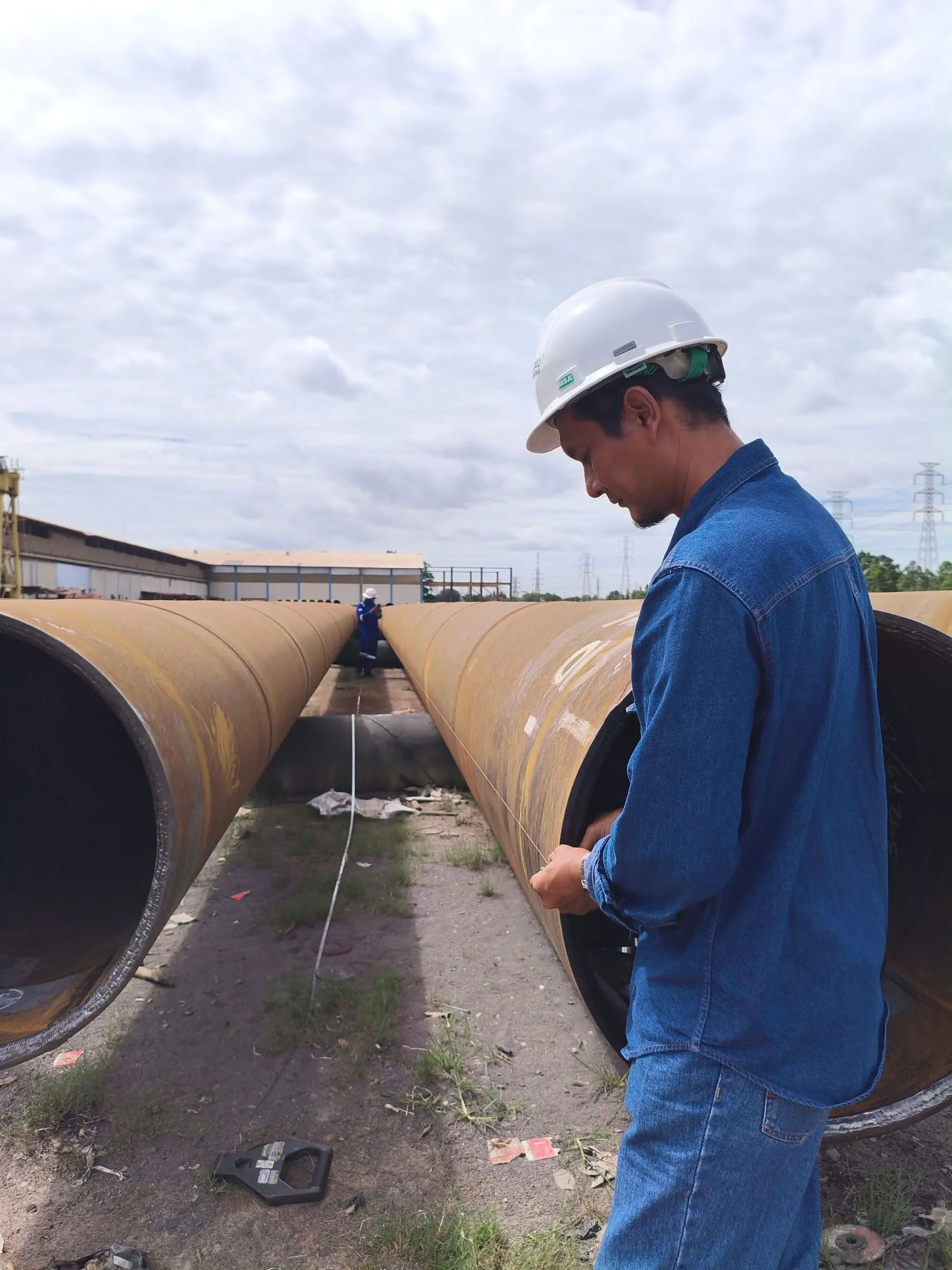 A field engineer inspecting pipeline infrastructure on site